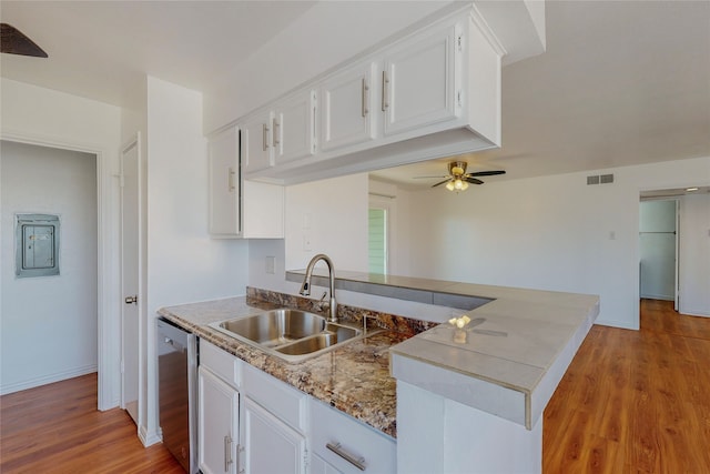 kitchen featuring sink, white cabinetry, light hardwood / wood-style flooring, stainless steel dishwasher, and kitchen peninsula