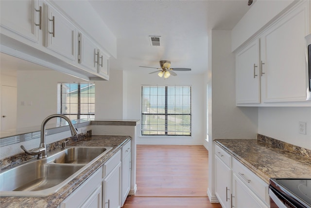 kitchen with white cabinetry, sink, light hardwood / wood-style floors, and ceiling fan