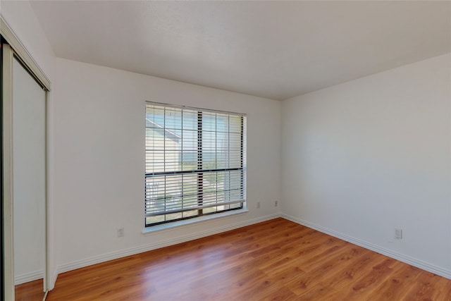 unfurnished bedroom with hardwood / wood-style floors and a closet