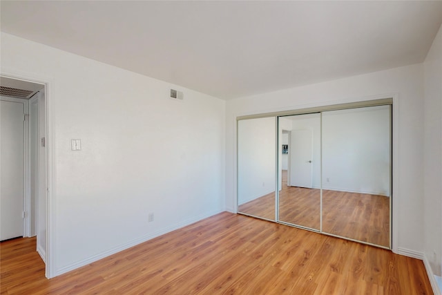 unfurnished bedroom featuring a closet and light hardwood / wood-style flooring