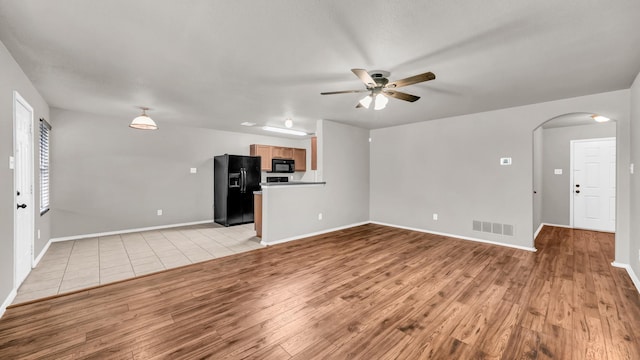 unfurnished living room with ceiling fan and light wood-type flooring