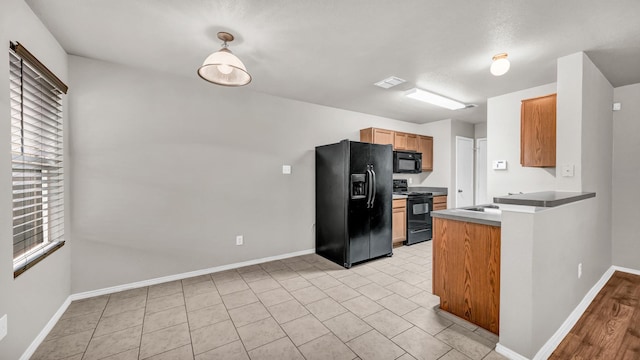 kitchen with light tile patterned flooring and black appliances