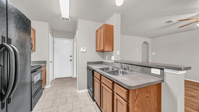 kitchen with sink, light tile patterned floors, kitchen peninsula, ceiling fan, and black appliances