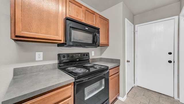 kitchen with light tile patterned flooring and black appliances