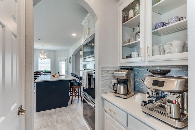 kitchen featuring stainless steel appliances, glass insert cabinets, and white cabinetry