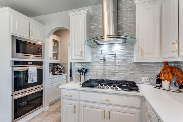 kitchen with backsplash, stainless steel appliances, hanging light fixtures, and white cabinets