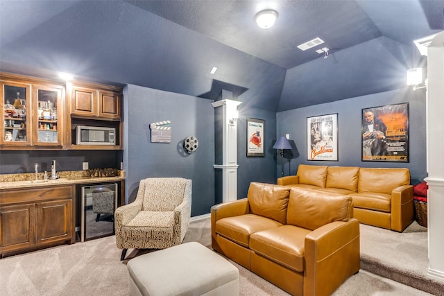 home theater room with decorative columns, wine cooler, visible vents, and indoor wet bar