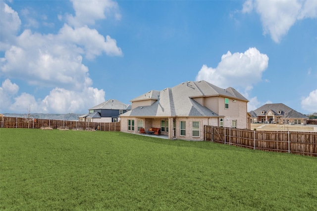 rear view of house with a lawn and a patio