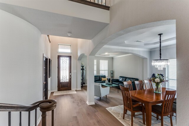 living room with a stone fireplace, light hardwood / wood-style flooring, high vaulted ceiling, and ceiling fan with notable chandelier