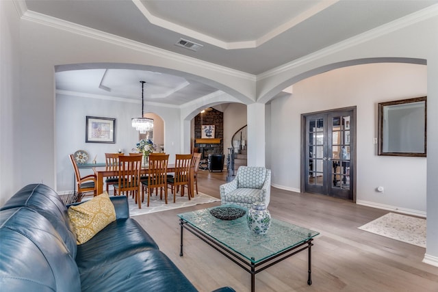 living area featuring baseboards, visible vents, a raised ceiling, and wood finished floors