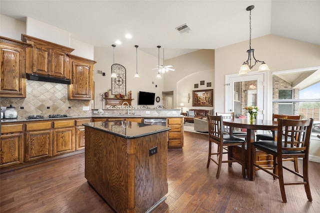 kitchen with vaulted ceiling, dark hardwood / wood-style floors, backsplash, stainless steel dishwasher, and black gas stovetop