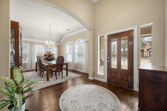 foyer featuring vaulted ceiling, dark hardwood / wood-style floors, and a chandelier