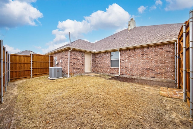 back of property featuring a yard and central AC unit