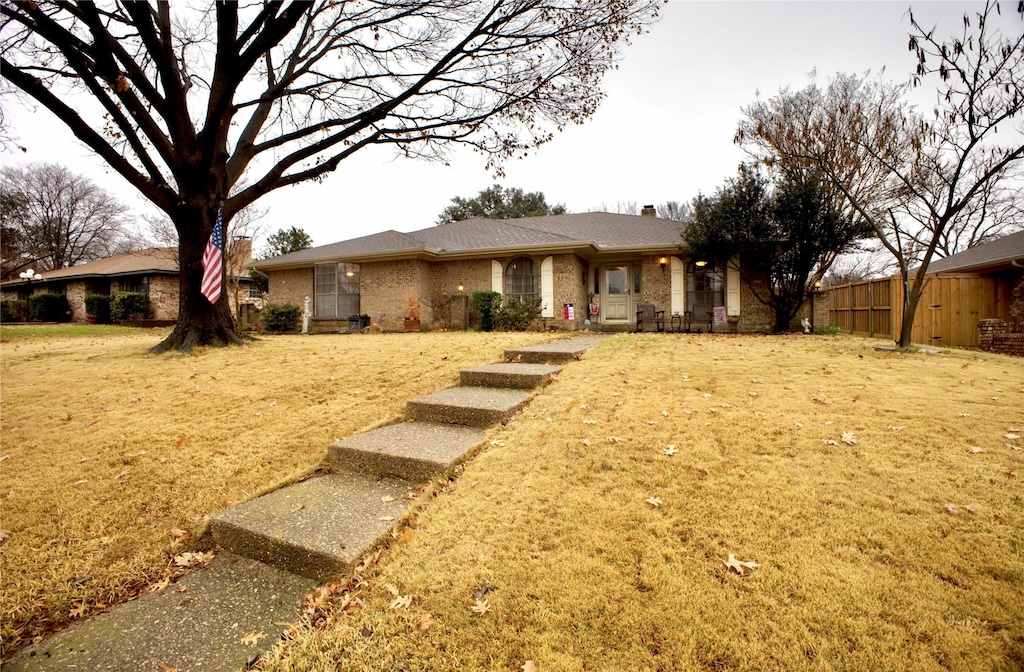 ranch-style home featuring a front lawn