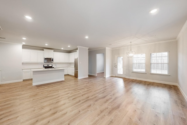 unfurnished living room with a notable chandelier, crown molding, and light hardwood / wood-style floors