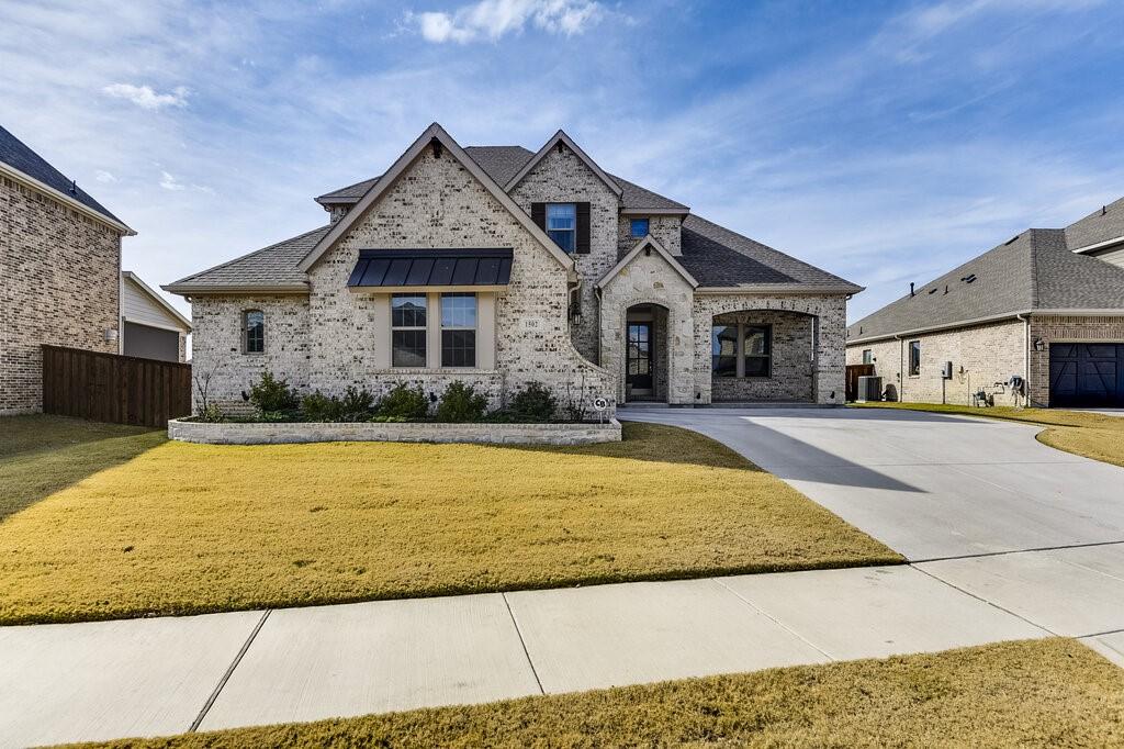 view of front of property with a garage, a front yard, and central air condition unit