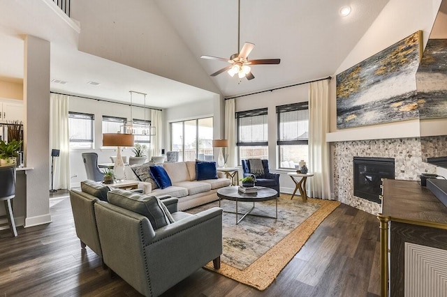 living room with a tiled fireplace, high vaulted ceiling, dark hardwood / wood-style floors, and ceiling fan