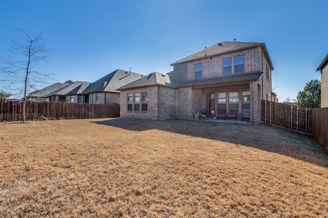 rear view of property featuring a yard and a patio