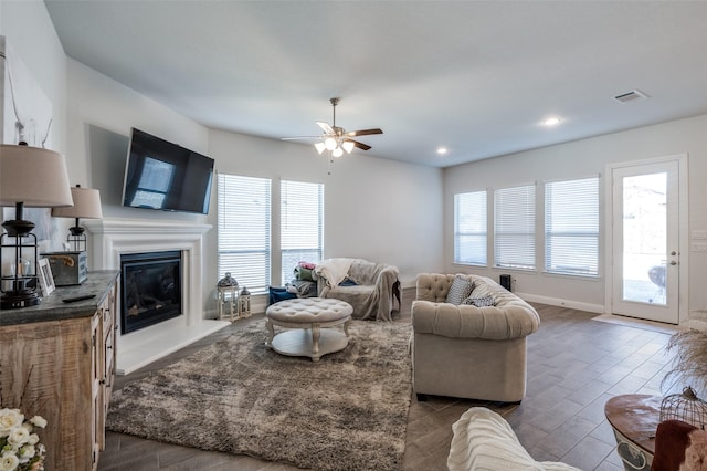 living room featuring dark wood-type flooring and ceiling fan