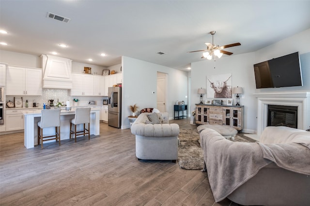 living room with ceiling fan and light hardwood / wood-style flooring