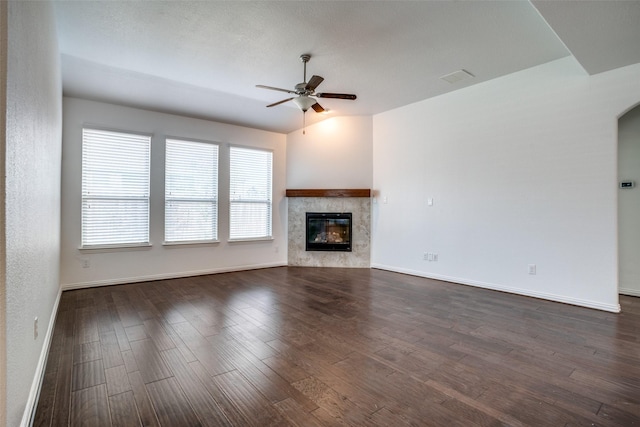 unfurnished living room featuring ceiling fan, a fireplace, lofted ceiling, and dark hardwood / wood-style floors