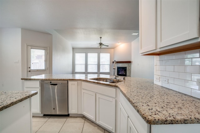 kitchen with sink, light stone counters, dishwasher, ceiling fan, and white cabinets