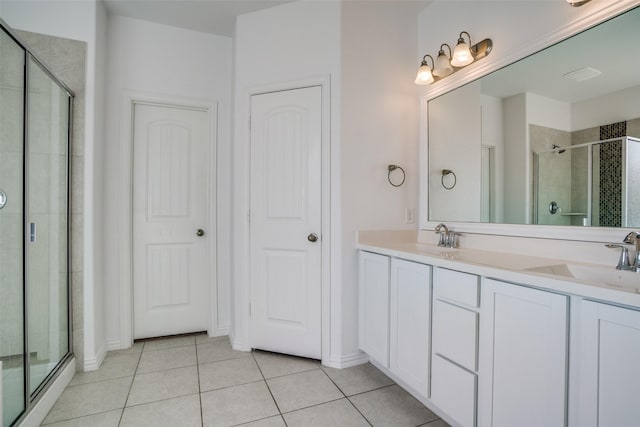 bathroom featuring tile patterned flooring, vanity, and a shower with shower door