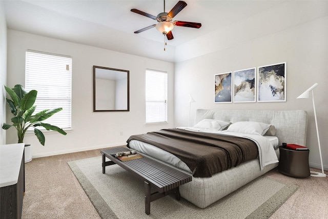 carpeted bedroom featuring ceiling fan and multiple windows