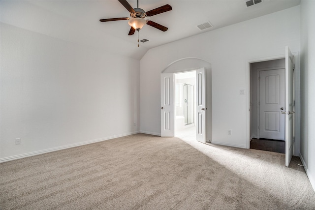 carpeted empty room featuring vaulted ceiling and ceiling fan