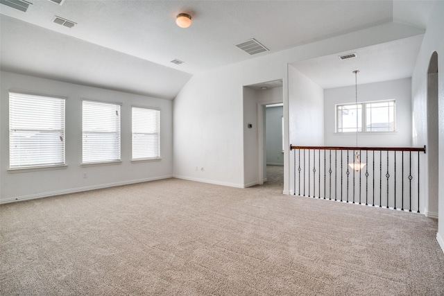 empty room featuring light colored carpet and vaulted ceiling