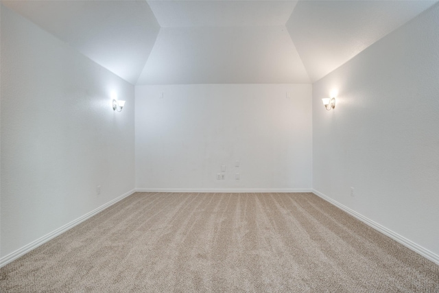 spare room with vaulted ceiling and carpet