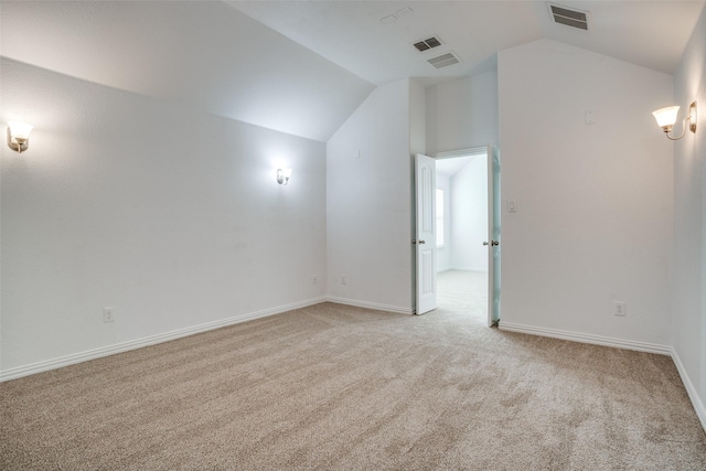 unfurnished room with lofted ceiling and light colored carpet