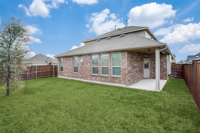 back of house with a patio and a lawn