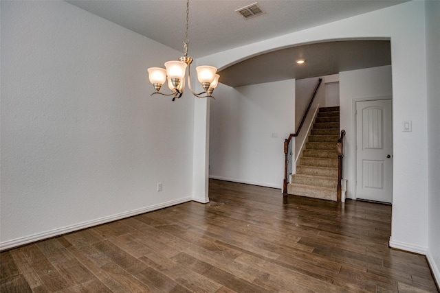 unfurnished room with dark hardwood / wood-style flooring, vaulted ceiling, and a chandelier