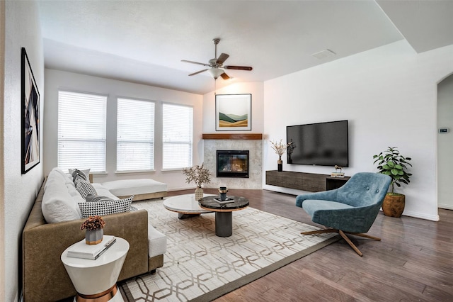 living room featuring a fireplace, hardwood / wood-style flooring, vaulted ceiling, and ceiling fan