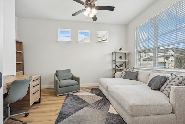 living room featuring ceiling fan, plenty of natural light, and light wood-type flooring