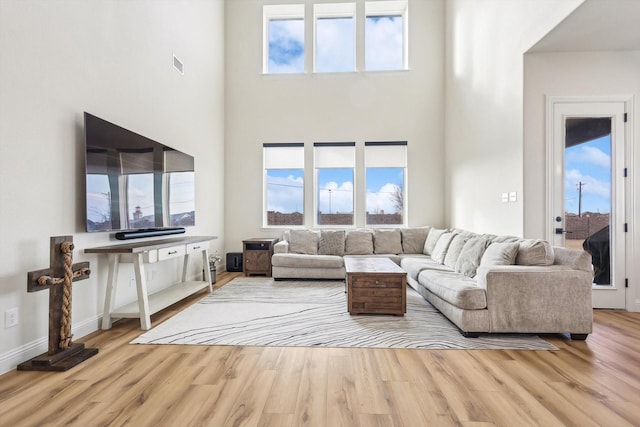 living room featuring a high ceiling and light wood-type flooring