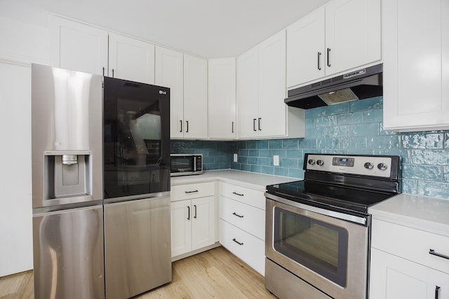 7935 Faithful Trl, Dallas, TX 75237 - kitchen with white cabinetry, appliances with stainless steel finishes, under cabinet range hood, light countertops, and backsplash