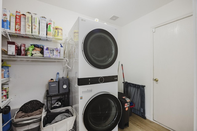 7935 Faithful Trl, Dallas, TX 75237 - laundry area with stacked washer / drying machine, wood finished floors, and laundry area