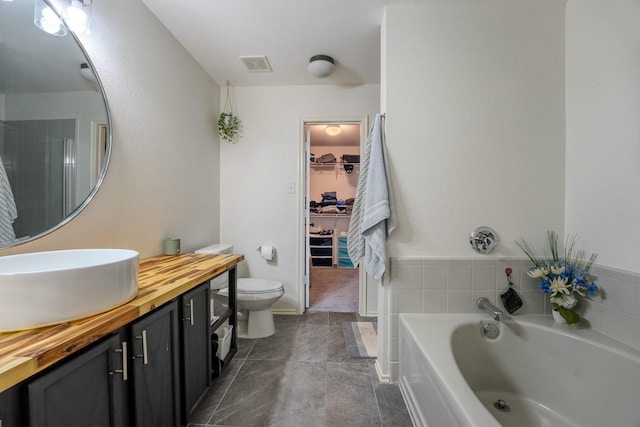 7935 Faithful Trl, Dallas, TX 75237 - bathroom with a garden tub, vanity, a spacious closet, visible vents, and toilet