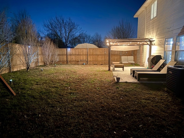 yard at twilight featuring cooling unit and a patio area