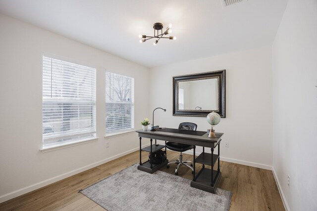 office area featuring a notable chandelier and dark hardwood / wood-style floors