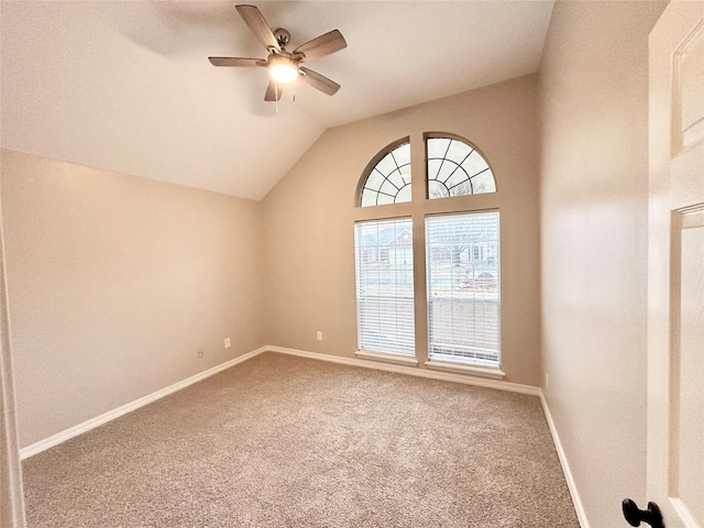 carpeted spare room with vaulted ceiling and ceiling fan