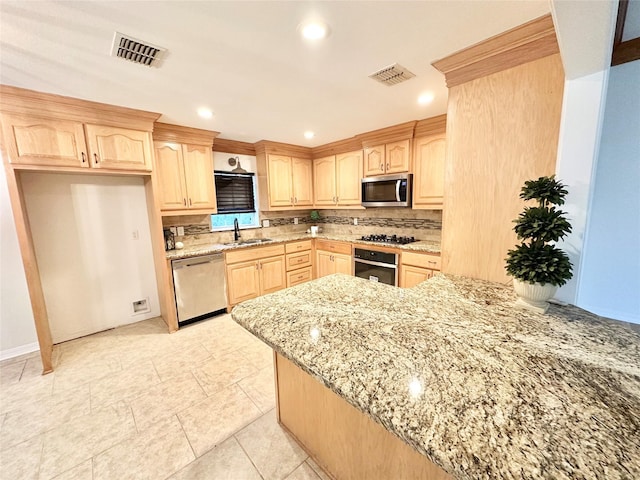 kitchen with light brown cabinetry, sink, stainless steel appliances, and light stone countertops