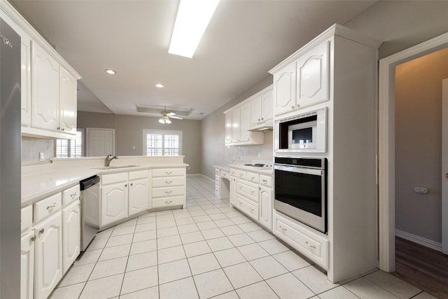 kitchen with sink, white cabinetry, light tile patterned floors, appliances with stainless steel finishes, and kitchen peninsula