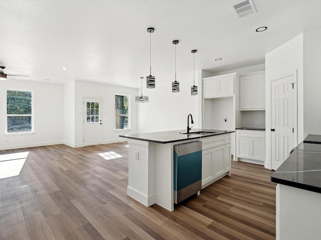 kitchen with white cabinetry, sink, an island with sink, and dishwasher