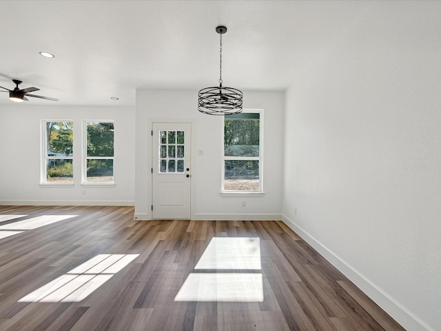 interior space with dark hardwood / wood-style flooring and ceiling fan with notable chandelier