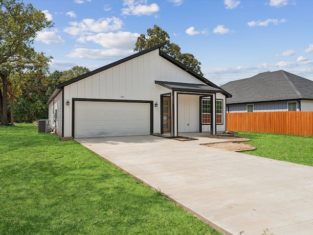 view of front facade with central AC, a garage, and a front yard