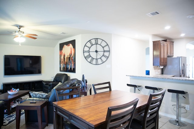 tiled dining space featuring ceiling fan