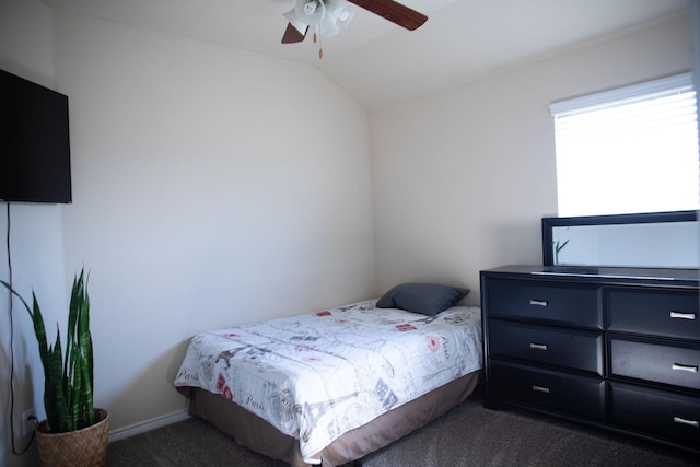 bedroom featuring ceiling fan, vaulted ceiling, and dark colored carpet